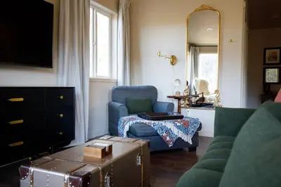 a living room with a blue chair and a mirror at Mountain cabin w game room & hot tub in Bailey