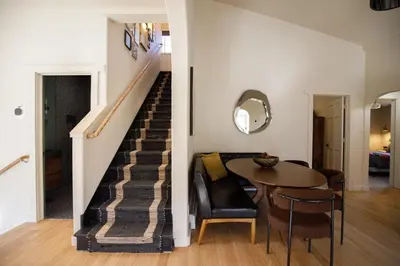 a living room and staircase with a table and chairs at Mountain cabin w game room & hot tub in Bailey