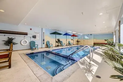 a swimming pool in a large room with chairs and tables at 5023 Gateway condo in Keystone