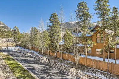 a house with a fence next to a road at 5023 Gateway condo in Keystone