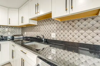 a kitchen with white cabinets and a sink at Family-Friendly Aurora Apt with Shared Patio! in Aurora