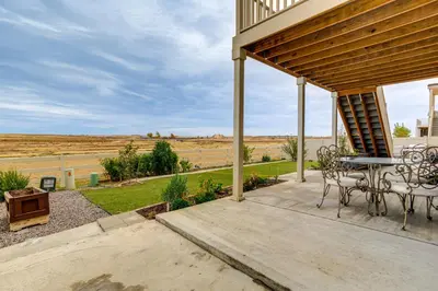 a patio with a table and chairs and a view of a field at Family-Friendly Aurora Apt with Shared Patio! in Aurora