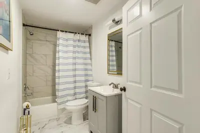 a white bathroom with a toilet and a sink at Family-Friendly Aurora Apt with Shared Patio! in Aurora