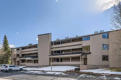 an apartment building with a car parked in a parking lot at Ski Run 307 - Mountain House Keystone in Keystone