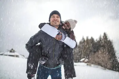 a man carrying a woman in the snow at Ski Run 307 - Mountain House Keystone in Keystone