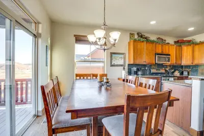 a kitchen with a wooden table and a dining room at Mtn Views and Private Hot Tub Granby Group Getaway! in Granby