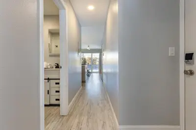 a hallway leading to a kitchen with white walls and wood floors at Meadow Cove B1 condo in Dillon
