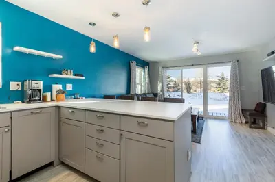 a kitchen with white cabinets and a blue wall at Meadow Cove B1 condo in Dillon