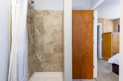 a bathroom with a shower with a wooden door at The Mall 1429 condo in Keystone