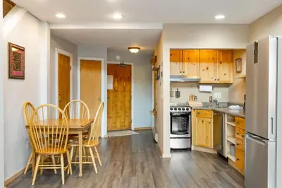 a kitchen with wooden cabinets and a table and chairs at The Mall 1429 condo in Keystone