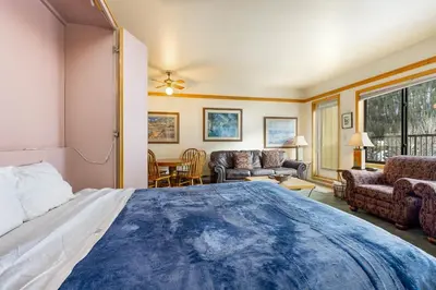 a bedroom with a large bed and a living room at 2797 Slopeside condo in Keystone