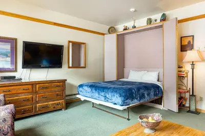 a bedroom with a bed and a flat screen tv at 2797 Slopeside condo in Keystone