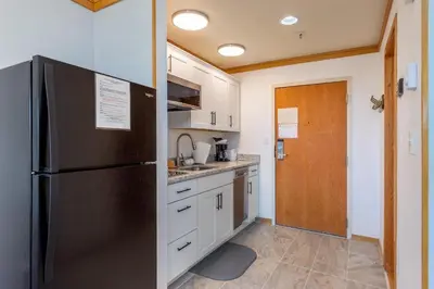 a kitchen with a black refrigerator and white cabinets at 2756 Slopeside condo in Keystone