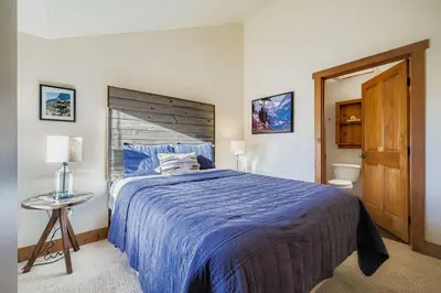 a bedroom with a bed with a blue comforter at 2301 Red Hawk Lodge condo in Snake River Health Services Incorporated Heliport