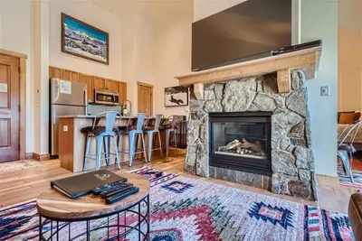 a living room with a stone fireplace with a tv at 2301 Red Hawk Lodge condo in Snake River Health Services Incorporated Heliport