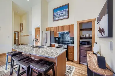 a kitchen with a counter and some chairs in it at 2301 Red Hawk Lodge condo in Snake River Health Services Incorporated Heliport