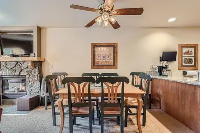 a dining room with a table and chairs and a fireplace at 2263 Red Hawk Lodge condo in Keystone