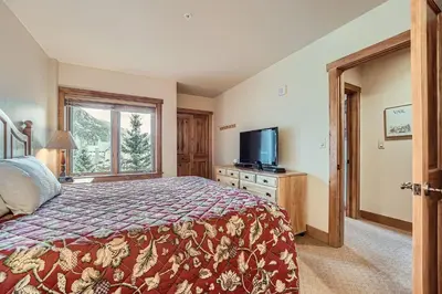 a bedroom with a bed and a tv and a window at 2263 Red Hawk Lodge condo in Keystone