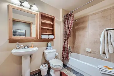a bathroom with a toilet and a sink and a tub at 2263 Red Hawk Lodge condo in Keystone
