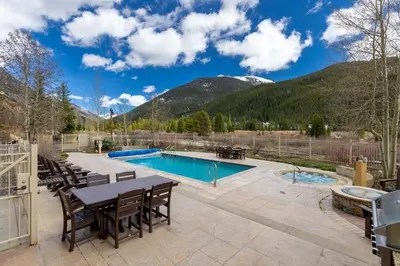 a patio with a table and chairs and a swimming pool at 2263 Red Hawk Lodge condo in Keystone