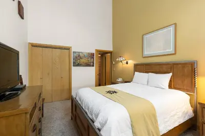 a bedroom with a bed and a flat screen tv at 2708 Chateaux DMont condo in Keystone