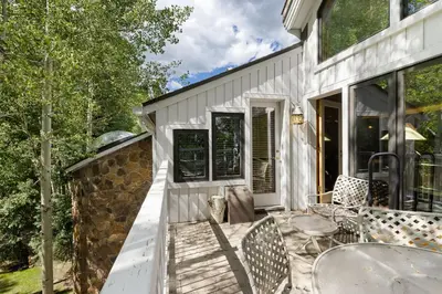 a white house with a patio with tables and chairs at 2708 Chateaux DMont condo in Keystone
