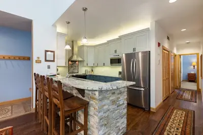 a kitchen with a counter and a refrigerator at 2708 Chateaux DMont condo in Keystone