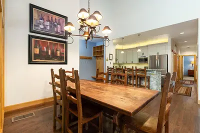 a dining room and kitchen with a wooden table and chairs at 2708 Chateaux DMont condo in Keystone