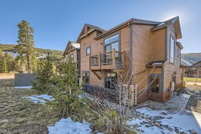 a large house with a deck on a yard at 58 River Run Townhomes townhouse in Keystone