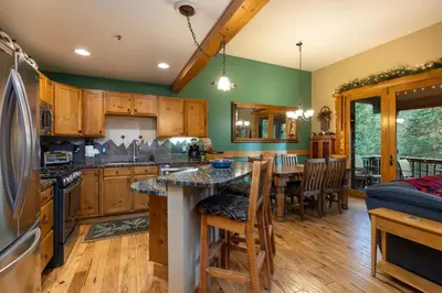 a kitchen with wooden cabinets and a table with chairs at 8766 Trappers Crossing townhouse in Keystone