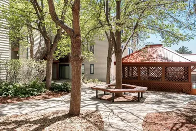 a picnic table in front of a house with trees at Code & Comfort | Boston Commons in Englewood