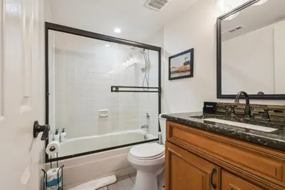 a bathroom with a toilet and a tub and a sink at Code & Comfort | Boston Commons in Englewood