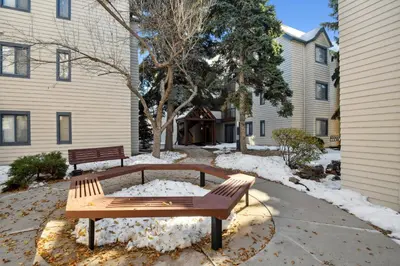 two benches sitting in the snow next to a building at Code & Comfort | Boston Commons in Englewood
