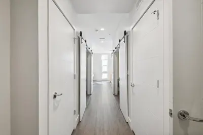 a hallway with white doors and wooden floors at Urban Elegance | Espadin LoHi in Denver