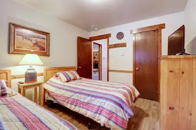 a bedroom with two beds and a cabinet and a lamp at A106 Lake Cliffe condo in Dillon