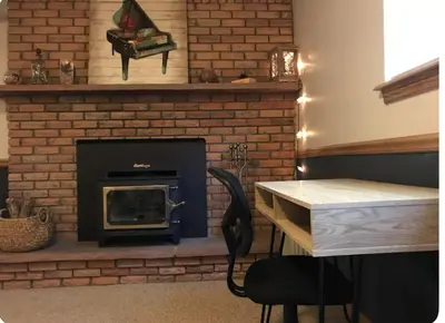 a brick fireplace with a table and a chair at Cozy Garden Level Apartment Studio by Lake Loveland in Loveland