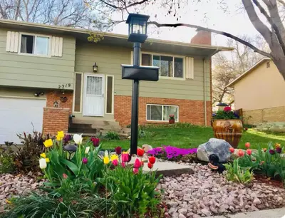 a street light in front of a house with flowers at Cozy Garden Level Apartment Studio by Lake Loveland in Loveland