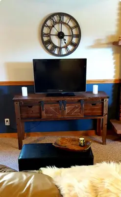 a living room with a tv and a clock on the wall at Cozy Garden Level Apartment Studio by Lake Loveland in Loveland