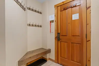 a hallway with a wooden door and a bench at Buffalo Lodge 8386 in Keystone