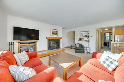 a living room with orange furniture and a flat screen tv at 2 Mi to Winter Park Resort Condo with Pool Access! in Winter Park