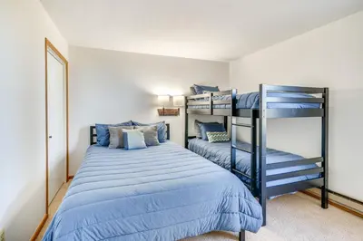 a bedroom with two bunk beds with blue sheets at 2 Mi to Winter Park Resort Condo with Pool Access! in Winter Park