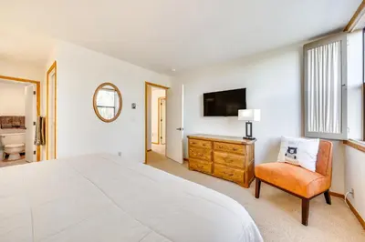 a bedroom with a bed and a chair and a television at 2 Mi to Winter Park Resort Condo with Pool Access! in Winter Park
