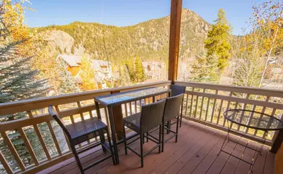 a balcony with two chairs and a table on it at Settlers Creek 6536 by SummitCove Lodging in Keystone