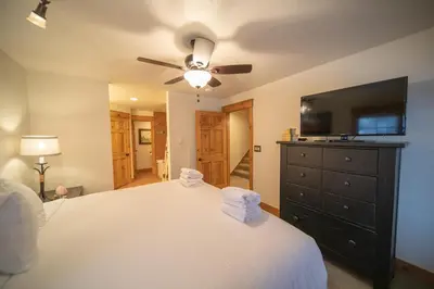a bedroom with a bed with a ceiling fan and a tv at Settlers Creek 6536 by SummitCove Lodging in Keystone