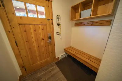 a room with a wooden door and a bench at Settlers Creek 6536 by SummitCove Lodging in Keystone