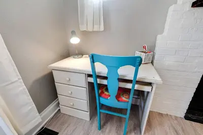 a blue chair sitting at a desk with a lamp at 94 WalkScore King Bed Capitol Hill Beachy Apt in Denver