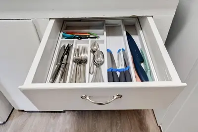 a drawer filled with utensils in a cabinet at 94 WalkScore King Bed Capitol Hill Beachy Apt in Denver