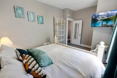 a bedroom with a white bed with pillows on it at 94 WalkScore King Bed Capitol Hill Beachy Apt in Denver