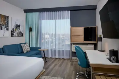 a hotel room with a bed and a couch and a window at Courtyard by Marriott Denver Downtown West in Denver