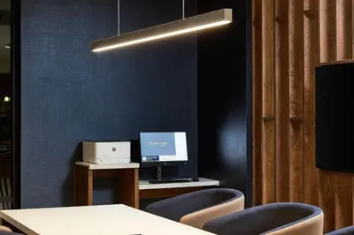 a room with a desk with a computer and chairs at Courtyard by Marriott Denver Downtown West in Denver